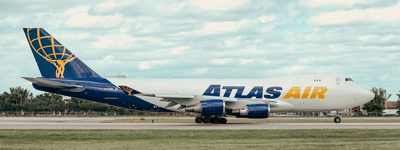 Home Side view of an Atlas Air cargo airplane taxiing on the runway at an airport.